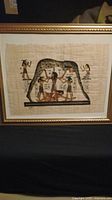 Framed Egyptian style painting on natural papyrus with figures and hieroglyphics.