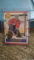 Front of Olaf Kolzig rookie card showing him in Washington Capitals goalie uniform with hockey net background.