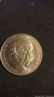 Front side of the coin showing Princess Diana and Prince Charles busts and inscription