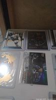 Various hockey cards laid out on a table in plastic sleeves showing multiple players including young guns and special editions.