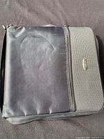 Closed black zippered carrying case for CDs showing front with minor surface marks.