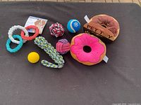 Overview of all dog toys showing two plush donuts, rubber rings, balls, and rope toys.