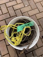 Top view of white bucket containing coiled brown sinking prawn line and bright yellow floating line with loop knot and metal clip.
