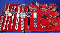 All 13 women's watches arranged on red fabric background showing various designs and bands.