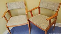 Both mid century Danish wood side chairs together showing fabric upholstery and wood frames
