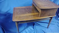 Mid-century Lane wood table two-tiered design with a drawer, angled side view