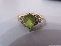 Front view showing pear-shaped peridot center and overall appearance