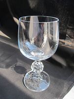 Close-up photo of single clear white wine glass with faceted decorative stem.
