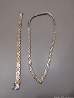 Full view of necklace and bracelet showing two-tone metal and overall design.