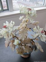 Overall view of jade flower sculpture showing blossoms, leaves, pot and stand