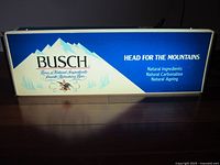 Front view of illuminated Busch light-up beer sign with mountain logo and marketing text.