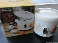 Photo showing the National SR-2183FK Electronic Rice Cooker/Warmer alongside its original box with matching floral design and model number printed on the box.