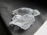 Crystal figurine showing two seals on a faceted ice floe base with clear details and faceting.