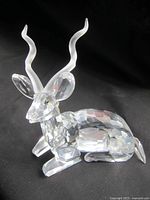 Crystal kudu antelope figurine photographed from the front-left angle on a black background showing detailed faceted body and frosted horns and ears.