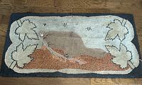Full view of the rectangular hooked rug showing the beaver in center with maple leaf border