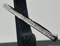 Side view of the Swarovski hinged bangle showing single row of sparkling clear crystals along the length.