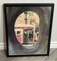 Full view of framed watercolour painting showing TTC Woodbine streetcar through portal with signature visible.