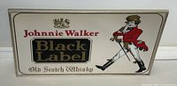 Full view of the Johnnie Walker Black Label framed bar mirror showing the complete logo, text, and striding man illustration.