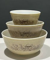 Three Pyrex nesting mixing bowls stacked to show size progression with Forest Fancies mushroom design