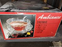 Photo of the punch bowl set packaging box showing product image and details such as bowl diameter (31 cm), cup capacity (6 oz), components included (1 bowl, 1 base, 12 cups, 12 hooks, 1 ladle).