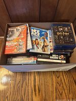 Box filled with assorted Blu-ray and DVD movies showing key titles like Horton Hears a Who, Ice Age: The Meltdown, and the Harry Potter series boxed set.