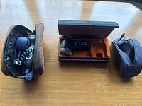 Three Philips electric shavers in their cases, including one with a hard rectangular case opened showing the shaver inside, and two others in soft fabric cases showing cord and shaver head.