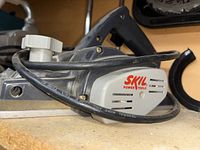 Close-up of Skil power tool belt sander with power cord visible