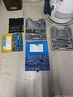 Full overview photo showing all five tool kits arranged on floor near water heater.