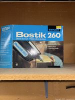 Photo of the Bostik 260 Electric Glue Gun original packaging in blue and white colors with brand and model visible.