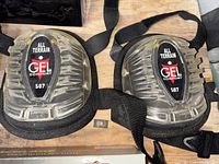 Pair of GEL Comfort All Terrain knee pads model 507, showing front view with clear plastic protective shell, gel cushioning, and adjustable black straps.