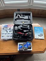Sony Video8 camcorder in carrying case with power cable, accessory guide, manuals, and blank tapes on table.