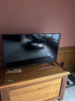 Full view of the 40-inch Vizio TV sitting on wooden furniture, showing overall condition and placement.