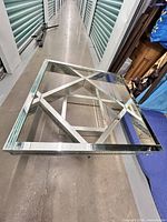 Photo showing top view of the glass top with mirrored edges and the twisted geometric base structure underneath.