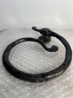 Close-up image showing circular black hammered metal wall hook with mounting base and curved hook end