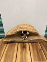 Front view of wooden sculpture displaying the natural arch and hollow knot-hole with the mouse figure inside