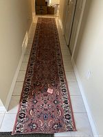 Full view of the carpet runner placed in a narrow hallway showing length and pattern.
