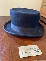 Front side view of a black felt top hat with a wide brim and rounded crown, labeled Lot 80.