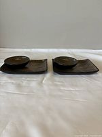 Set of two sushi plates each with a matching bowl, dark color with ridged linear textured pattern, arranged side by side