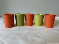 Five children's cups arranged side by side, showing color and size.
