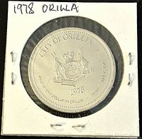 Obverse side of 1978 City of Orillia trade dollar coin showing city crest, motto, and year