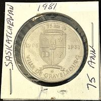 Obverse side of the 1981 Gravelbourg trade dollar coin showing the town crest with dates 1906 and 1981 and the inscription 'VILLE DE GRAVELBOURG'.