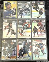 Photo of 9 Topps Gold Label hockey cards in plastic sleeves showing front designs with player action shots and portraits.
