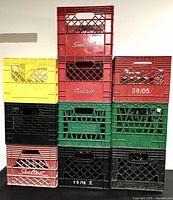 Front view of stacked plastic crates showing colors and brands