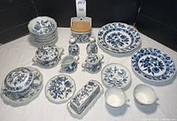 Full lot assortment of Blue Danube pattern dishes laid out showing plates, covered pieces, salt and pepper shakers, and serving dishes.