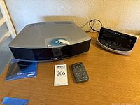 Front view of Bose Wave Music System IV with remote control and user manual on table