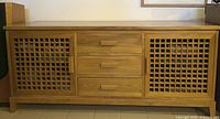 Front view of entertainment credenza with closed drawers and lattice doors