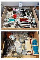 Top view of a kitchen drawer containing graters, measuring cups and spoons, nutcracker, whisks, glass and plastic containers and various small kitchen utensils.