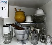 Overview of lot with yellow honey pot, butter dishes, mortar and pestle, soy sauce dispensers, and salt pepper shakers
