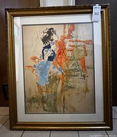 Front view of abstract painting featuring figure in blue and orange hues, in gold frame with matting.