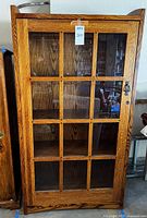 Full front view of oak mission style bookcase with glass‐paneled door